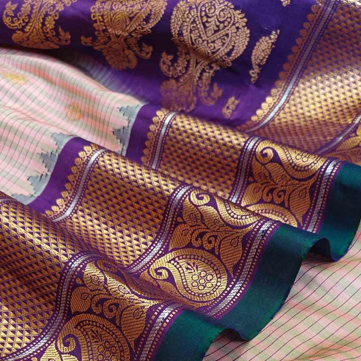 Peach Gadwal silk saree with grey checks and small butta body, purple zari border with mango and leaf motifs, plain purple blouse.