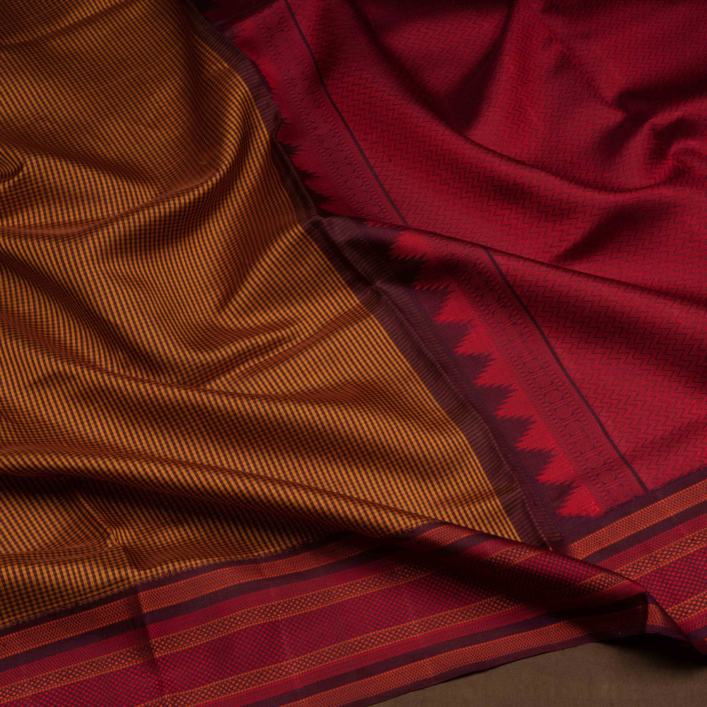 Mustard Gadwal silk saree with brown micro checks body, contrasting woven border with stripes and diamond patterns, brown pallu with temple motifs.