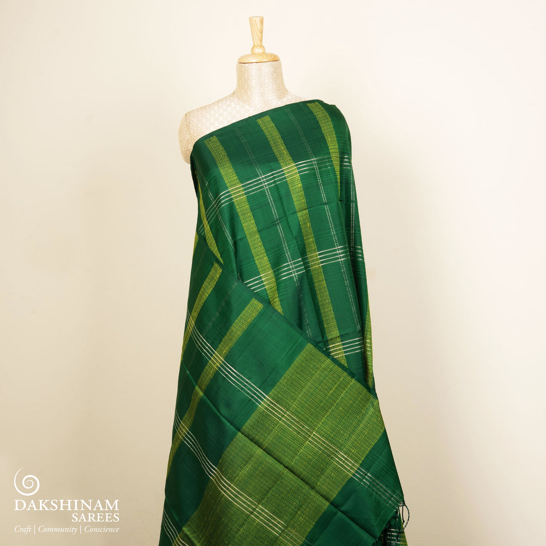Green soft silk saree with lime yellow stripe and dash threadwork and silver zari lines, paired with a plain blouse with zari detailing.