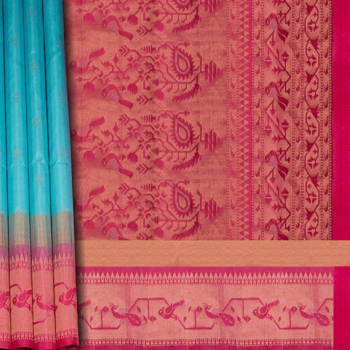 Light blue soft silk saree with silver butta allover, pink and gold zari border and pink pallu with bird and plant motifs.