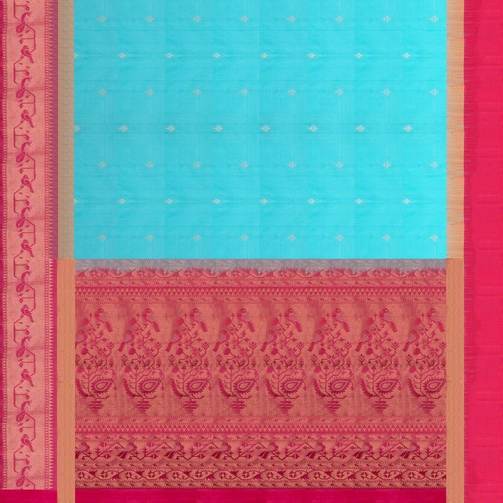 Light blue soft silk saree with silver butta allover, pink and gold zari border and pink pallu with bird and plant motifs.
