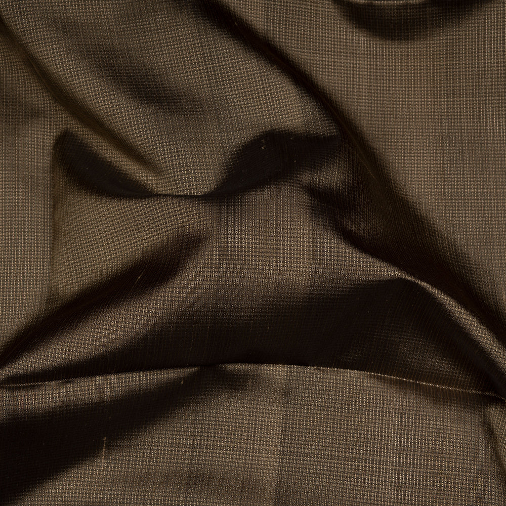 Beige soft silk saree with self-textured body, plain border and beige pallu with floral vine, lotus and chevron motifs in black and gold zari, paired with black blouse.