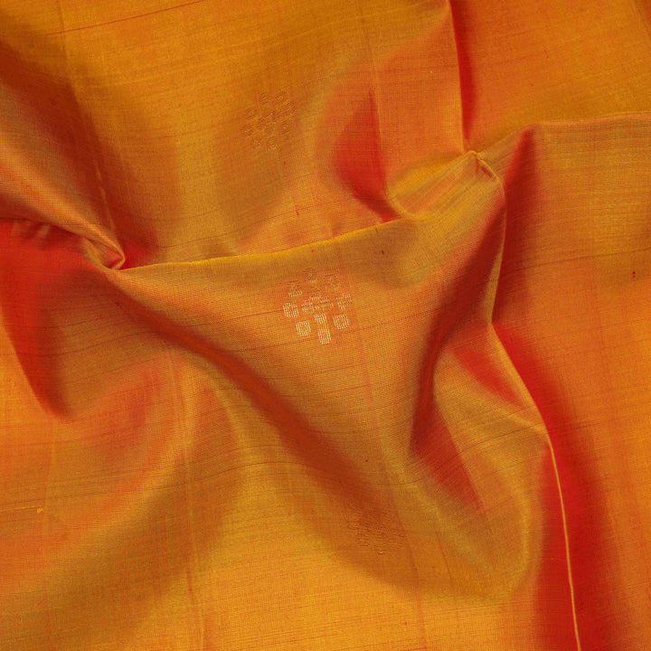 Orange soft silk saree with floral butta body, maroon border with paisley and chevron motifs, and maroon pallu with diamond floral patterns.