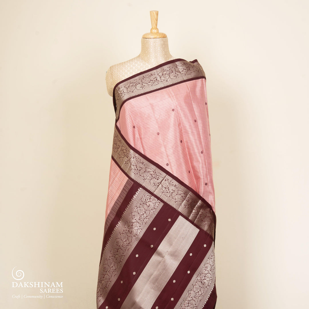 Peach handwoven Kanjivaram silk saree with horizontal stripes and chakram buttas, maroon border with parrot and floral motifs, and matching maroon blouse.