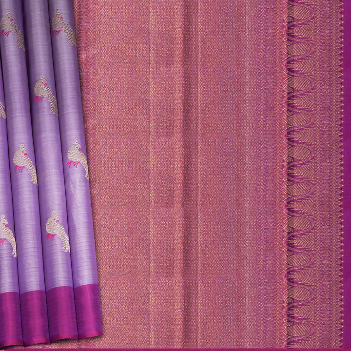 Purple handwoven Kanjivaram silk saree with meenakari parrot motifs, magenta border, detailed pallu with mango, thazampoo, and temple designs, paired with magenta blouse.