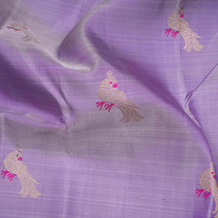 Purple handwoven Kanjivaram silk saree with meenakari parrot motifs, magenta border, detailed pallu with mango, thazampoo, and temple designs, paired with magenta blouse.