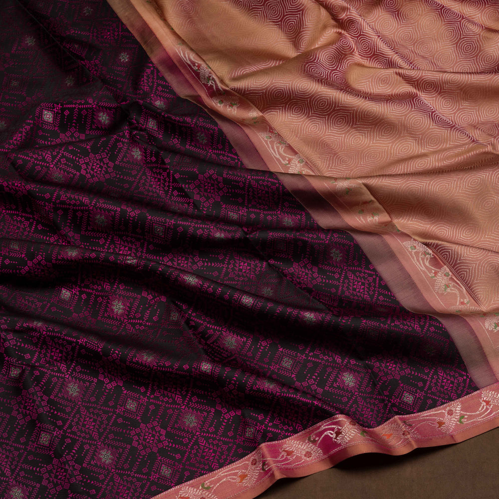 Black handwoven Kanjivaram silk saree with pink thread work, diamond and star zari motifs, peach floral meenakari border, and matching pallu, paired with peach blouse.