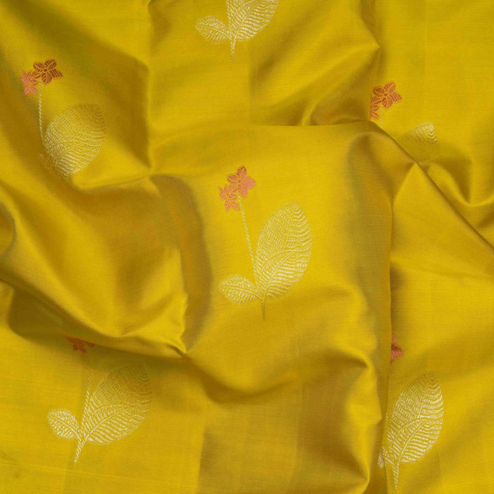 Lime green handwoven Kanjivaram silk saree with floral and leaf motifs, rose design pallu, borderless style, paired with light blue blouse with silver zari stripes.