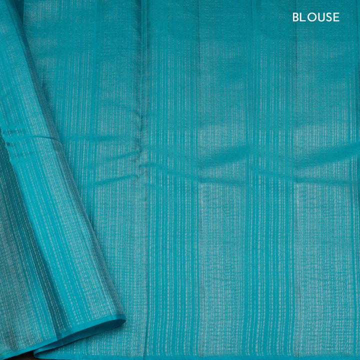Lime green handwoven Kanjivaram silk saree with floral and leaf motifs, rose design pallu, borderless style, paired with light blue blouse with silver zari stripes.