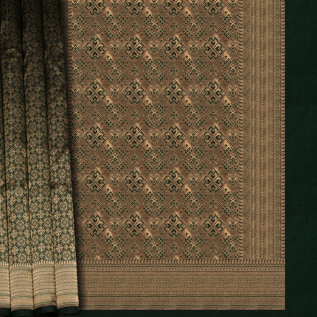 Dark green Banarasi silk saree with all-over gold brocade featuring round and diamond buttas, intricate zari border with chevron and traditional motifs, paired with a plain dark green blouse.