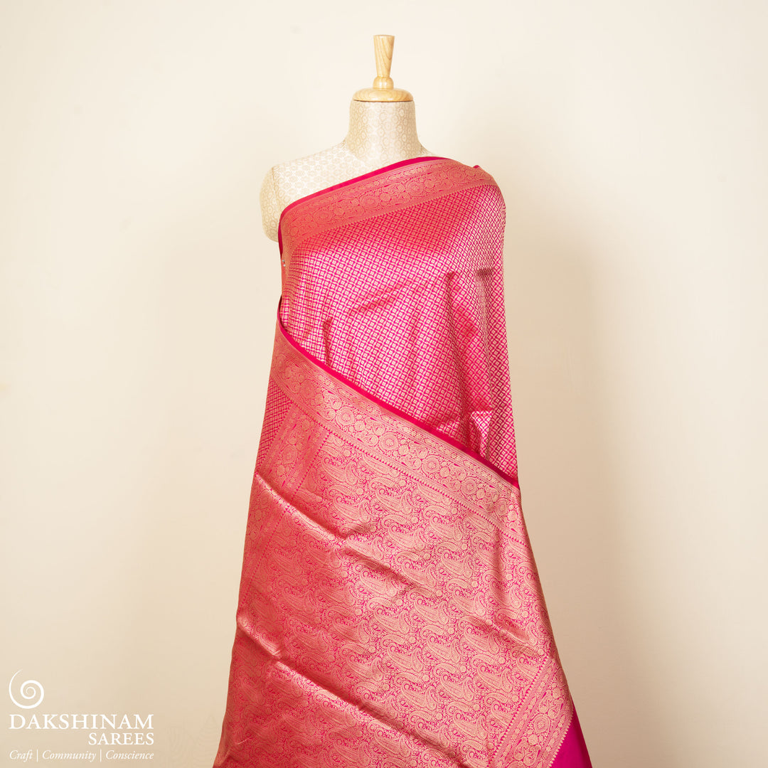 Pink Banarasi silk saree with gold brocade, diamond and vaira mookuthi buttas, paisley border with dotted and malli moggu design and matching pallu.