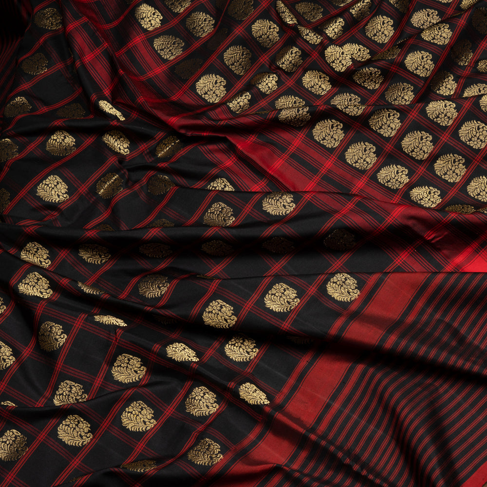 Black Pochampally Ikat silk saree with ikat checks, kadiyal butta, black border with red panel and rectangular patterns, paired with off-white ikat blouse.