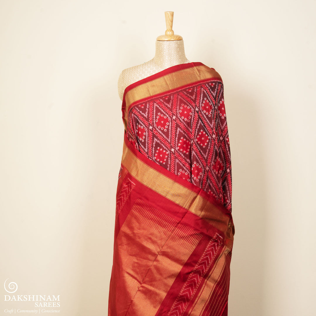Red Pochampally Ikat silk saree with diamond motifs, red and gold zari border, and temple design pallu with arrow patterns, paired with plain red blouse with zari border.