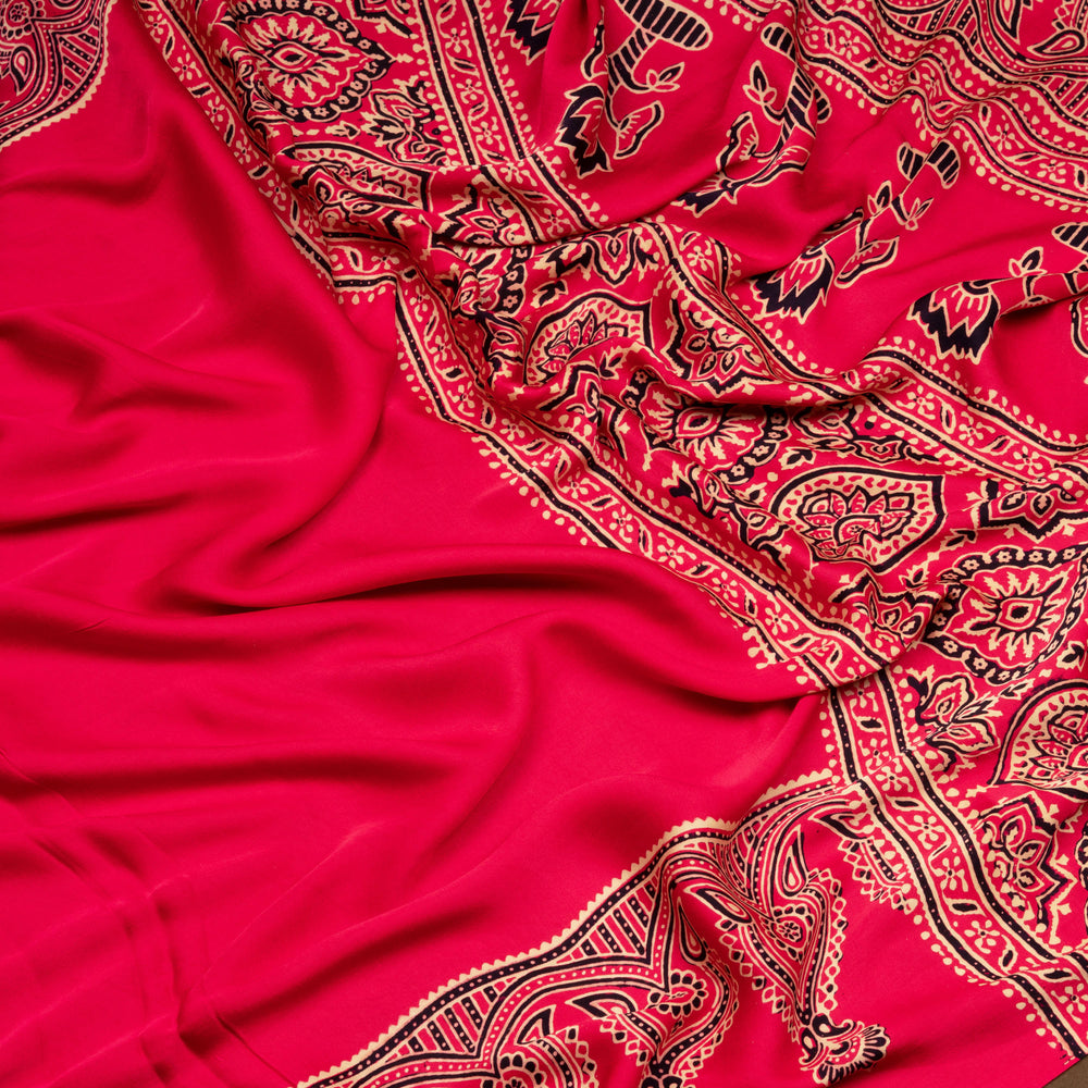 Pink handwoven modal silk saree with plain pink body, Ajrakh printed border, gold zari pallu, paired with a pink Ajrakh design blouse.