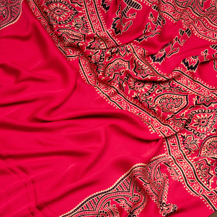 Pink handwoven modal silk saree with plain pink body, Ajrakh printed border, gold zari pallu, paired with a pink Ajrakh design blouse.