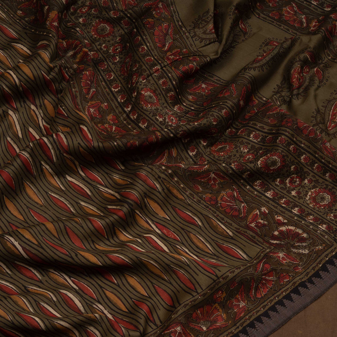 Army green handwoven Chanderi silk saree with yellow and red Ajrakh print, gicha temple border, floral pallu design, paired with green blouse with chevron lines.