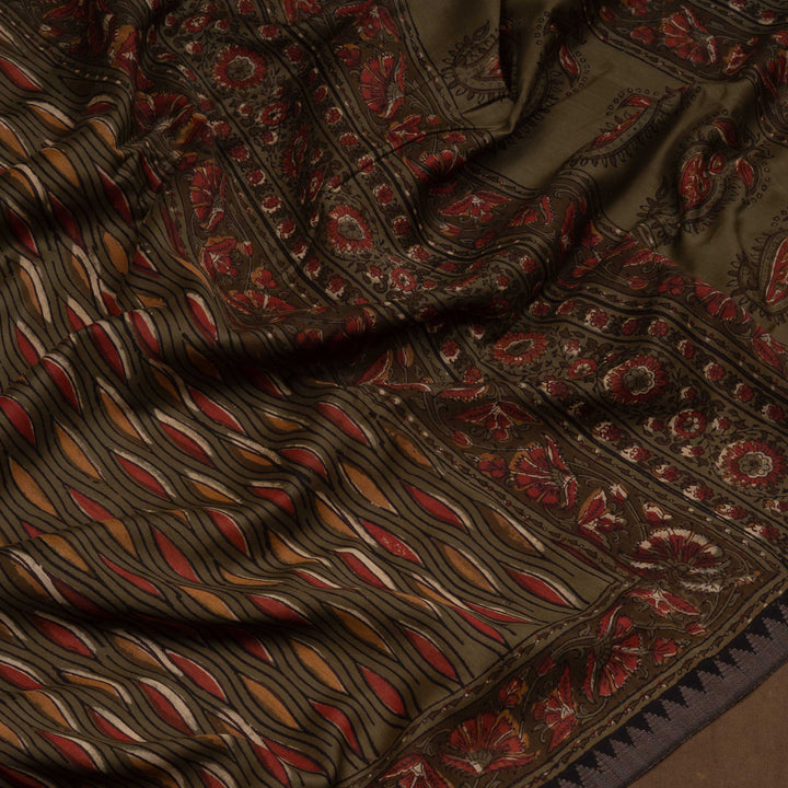 Army green handwoven Chanderi silk saree with yellow and red Ajrakh print, gicha temple border, floral pallu design, paired with green blouse with chevron lines.