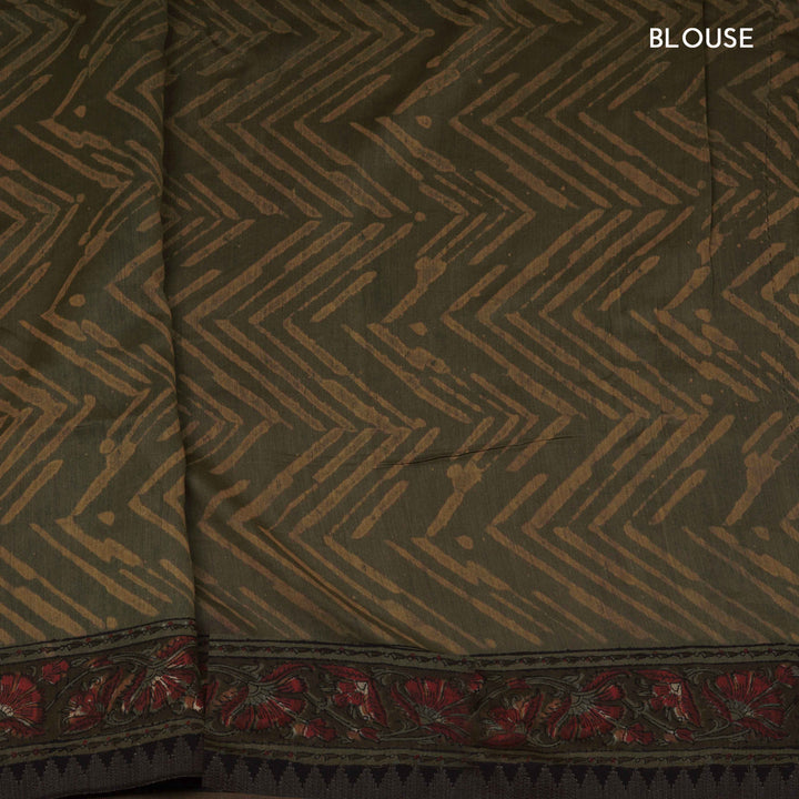 Army green handwoven Chanderi silk saree with yellow and red Ajrakh print, gicha temple border, floral pallu design, paired with green blouse with chevron lines.