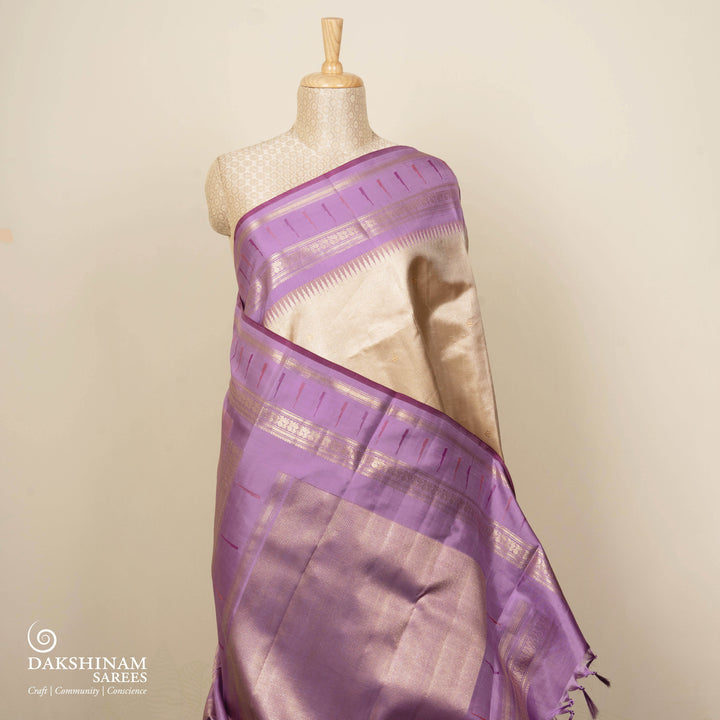 Cream Kanjivaram silk saree with tissue body, silver zari floral butta, lavender Paithani border and annam design pallu with matching blouse