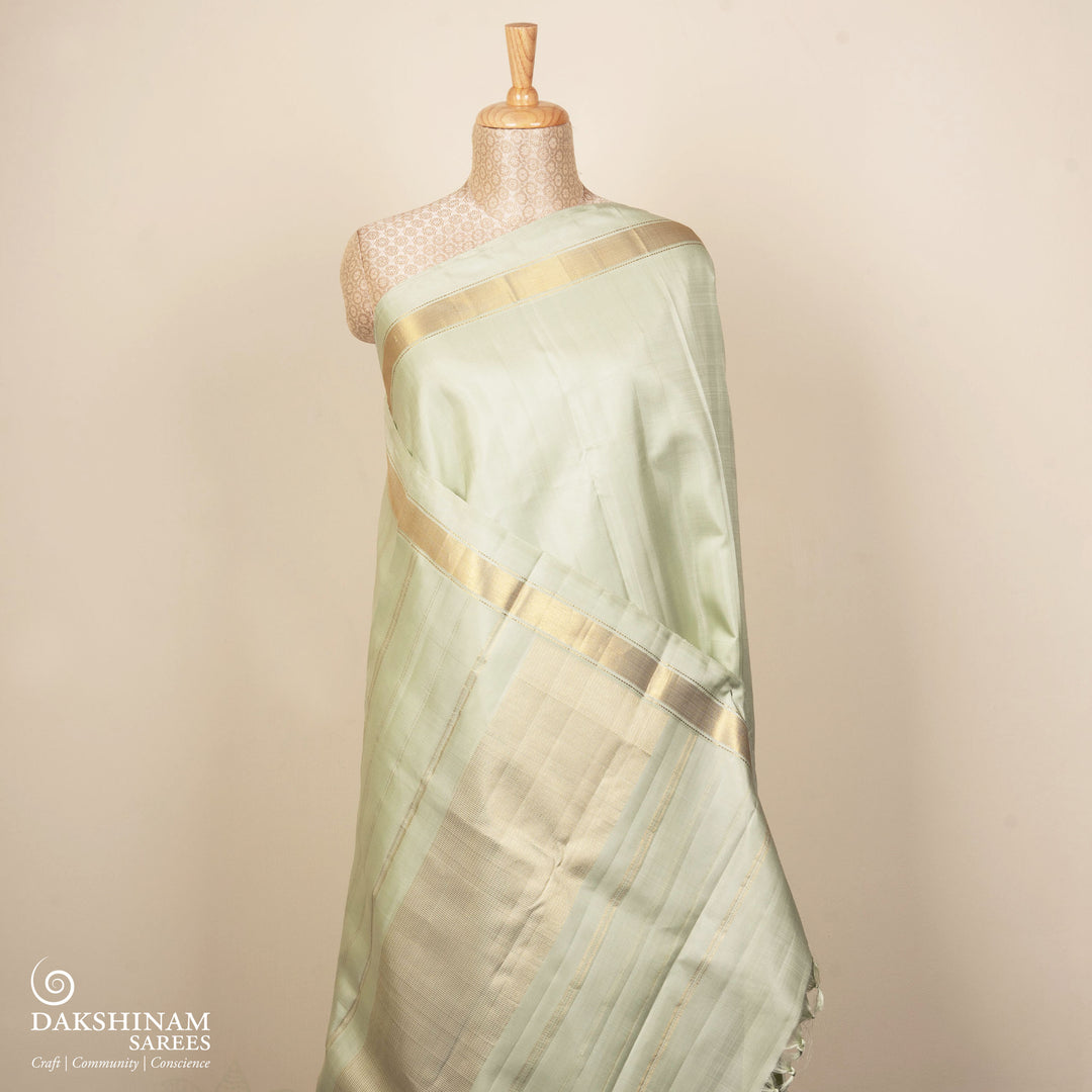 Light green Kanjivaram silk saree with gold zari diagonal chevron lines and striped panel pallu with matching blouse