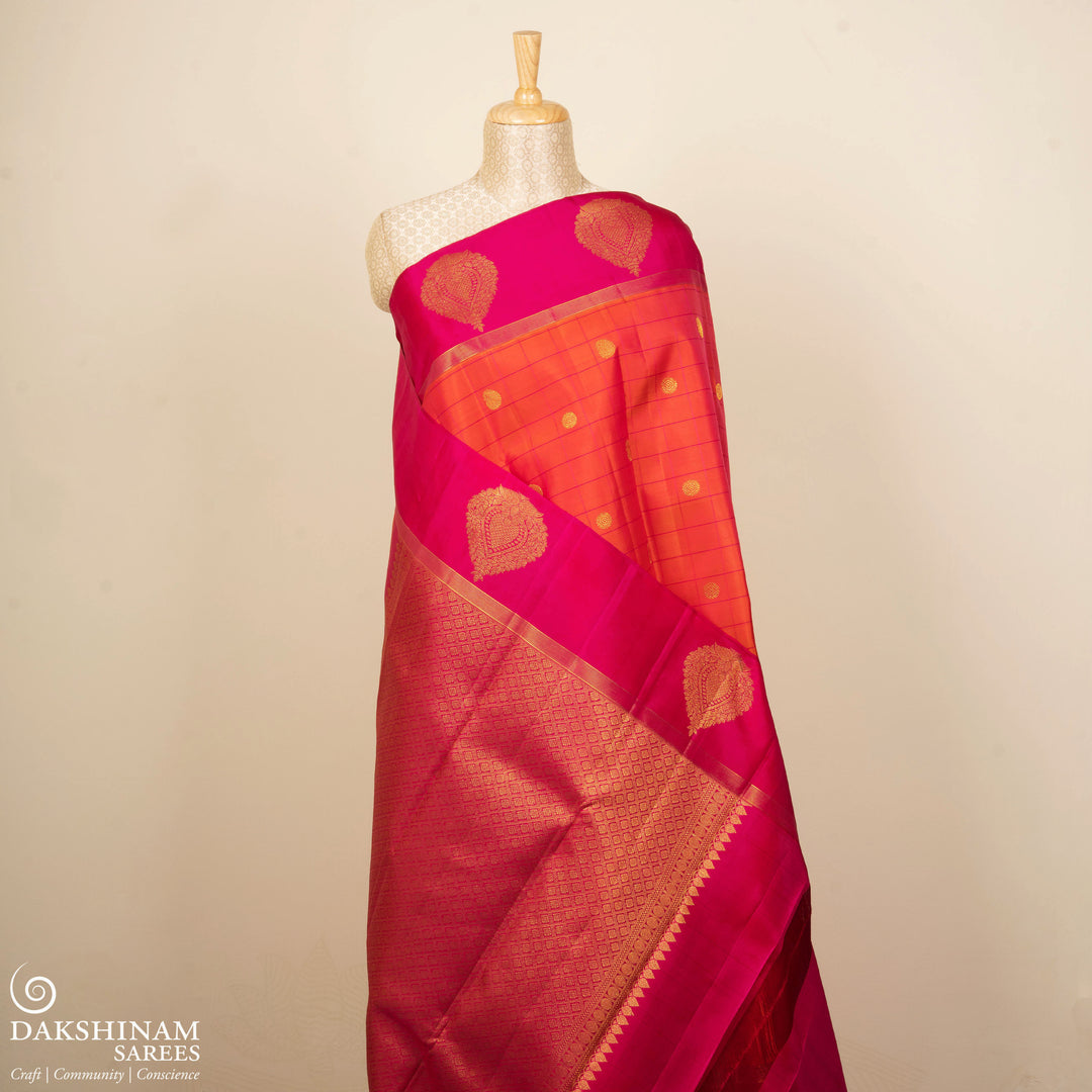 Orange Kanjivaram silk saree with checks, chakram and mango butta, magenta leaf border and vaira mookuthi pallu with matching blouse
