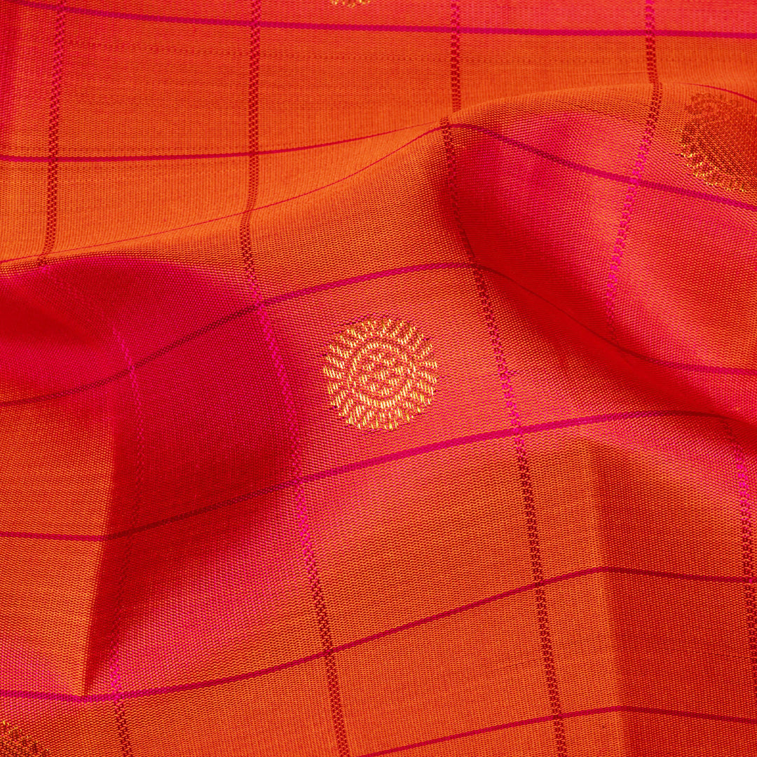 Orange Kanjivaram silk saree with checks, chakram and mango butta, magenta leaf border and vaira mookuthi pallu with matching blouse