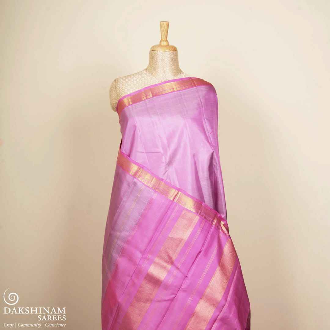 Lavender Kanjivaram silk saree with plain body, light pink diagonal mango butta border and gold zari striped pallu with matching blouse