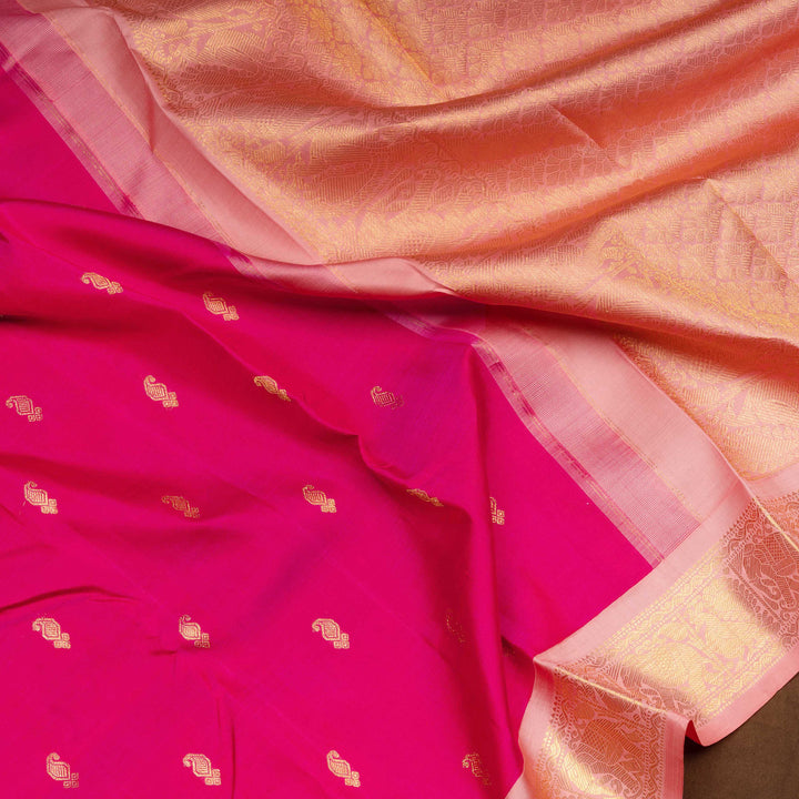 Pink Kanjivaram silk saree with gold zari mango butta, light pink pallu with peacock and elephant motifs, and matching blouse