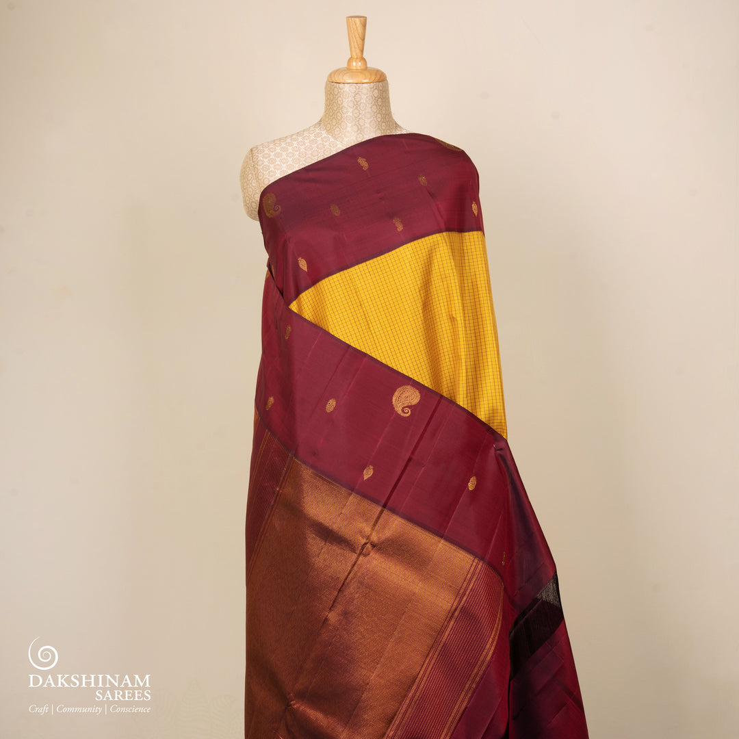 Yellow Kanjivaram silk saree with maroon checks, floral and mango butta border, and panel line pallu with matching blouse
