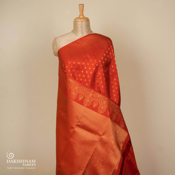 Orange Kanjivaram silk saree with allover diamond butta, turning border and rich pallu with rudraksham, chevron lines and retta killi motifs