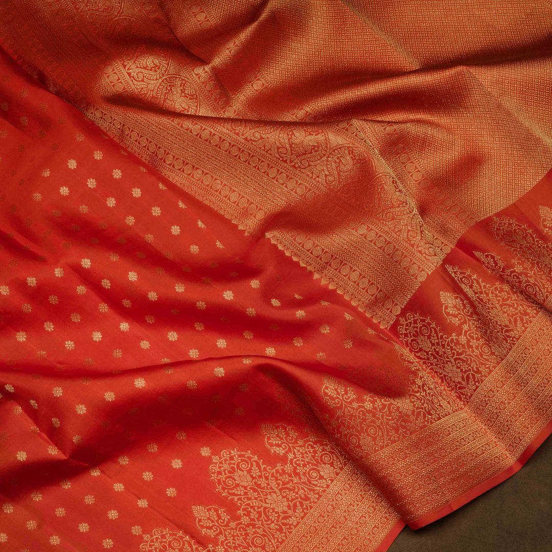 Orange Kanjivaram silk saree with allover diamond butta, turning border and rich pallu with rudraksham, chevron lines and retta killi motifs
