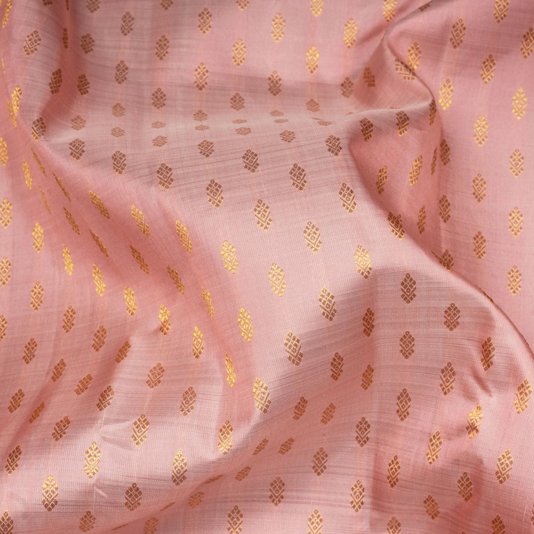 Light peach Kanjivaram silk saree with vairam buttas, peach pink border featuring temple and chevron designs, and detailed zari pallu, paired with plain blouse.