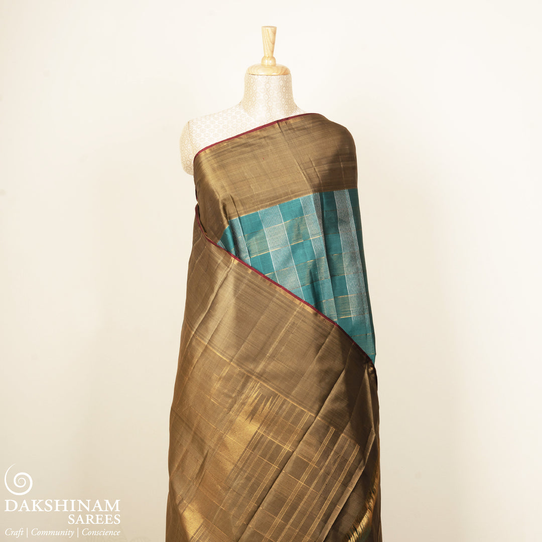 Aqua blue Kanjivaram silk saree with gold and silver zari checks, taupe brown temple border and matching blouse