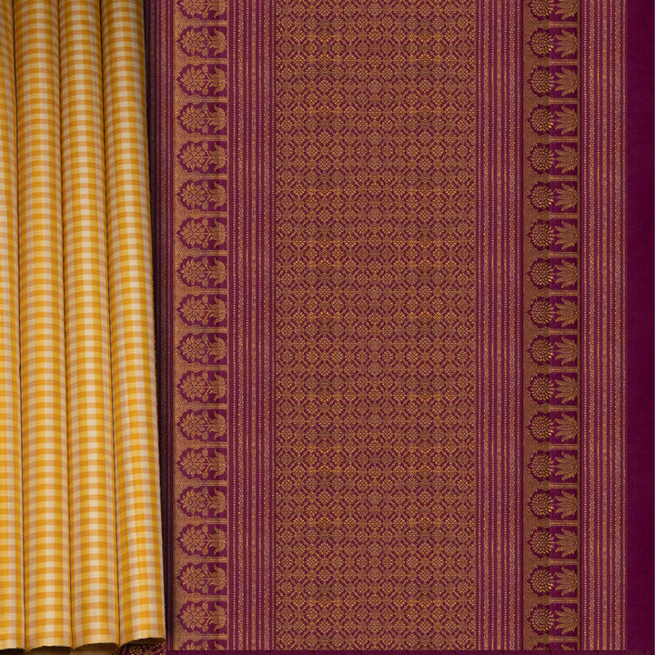 Beige and yellow small checked Kanjivaram silk saree with purple pallu featuring floral motifs, chevron and chakram designs, paired with dotted butta blouse.