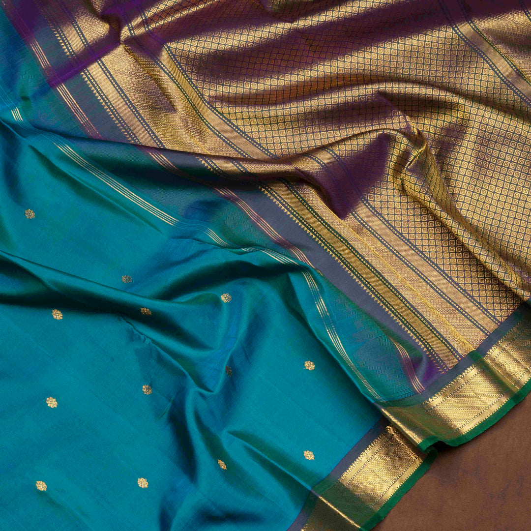 Peacock blue Kanjivaram silk saree with floral butta, dark blue zari border and diamond panel pallu with matching blouse