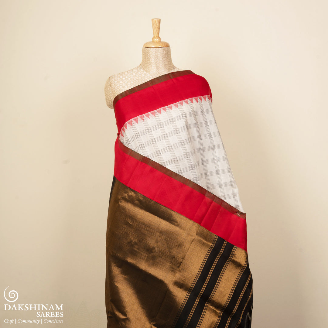 White Gadwal cotton saree with black checks, red Korvai temple border and brown pallu