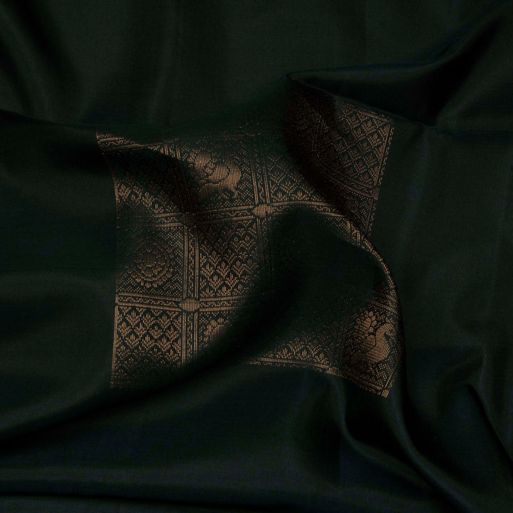 Dark green soft silk saree with gold and silver zari annam, chakram and floral motifs