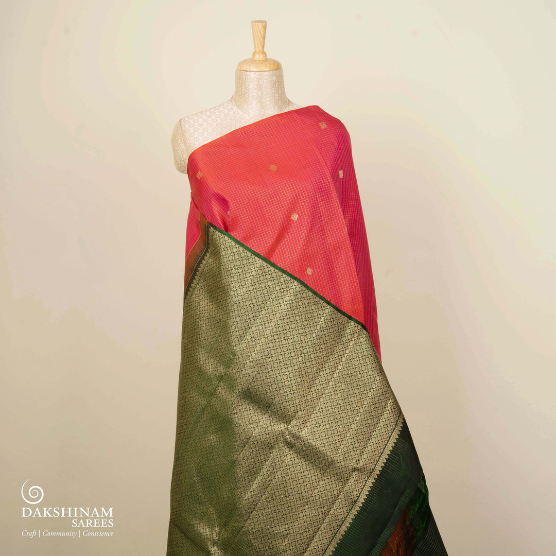 Orange Kanjivaram silk saree with pink-tone vairoosi checks, annam and vaira mookuthi butta, green pallu and matching blouse