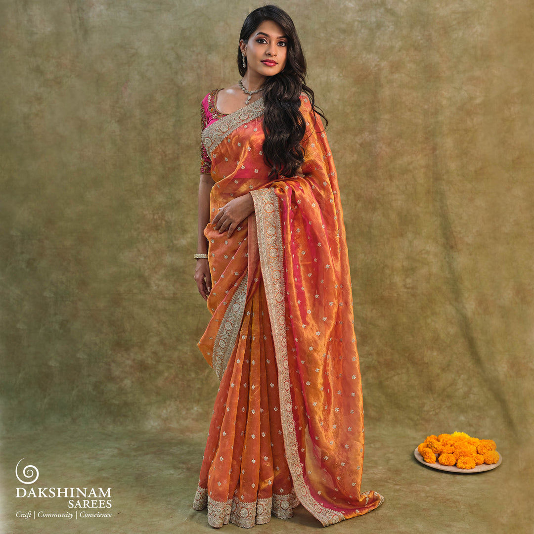 Orange embroidered tissue organza silk saree with small leaf zardozi buttas, ornate embroidered border and embroidered blouse.