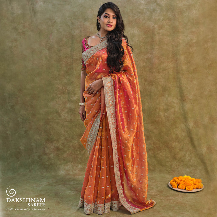 Orange embroidered tissue organza silk saree with small leaf zardozi buttas, ornate embroidered border and embroidered blouse.