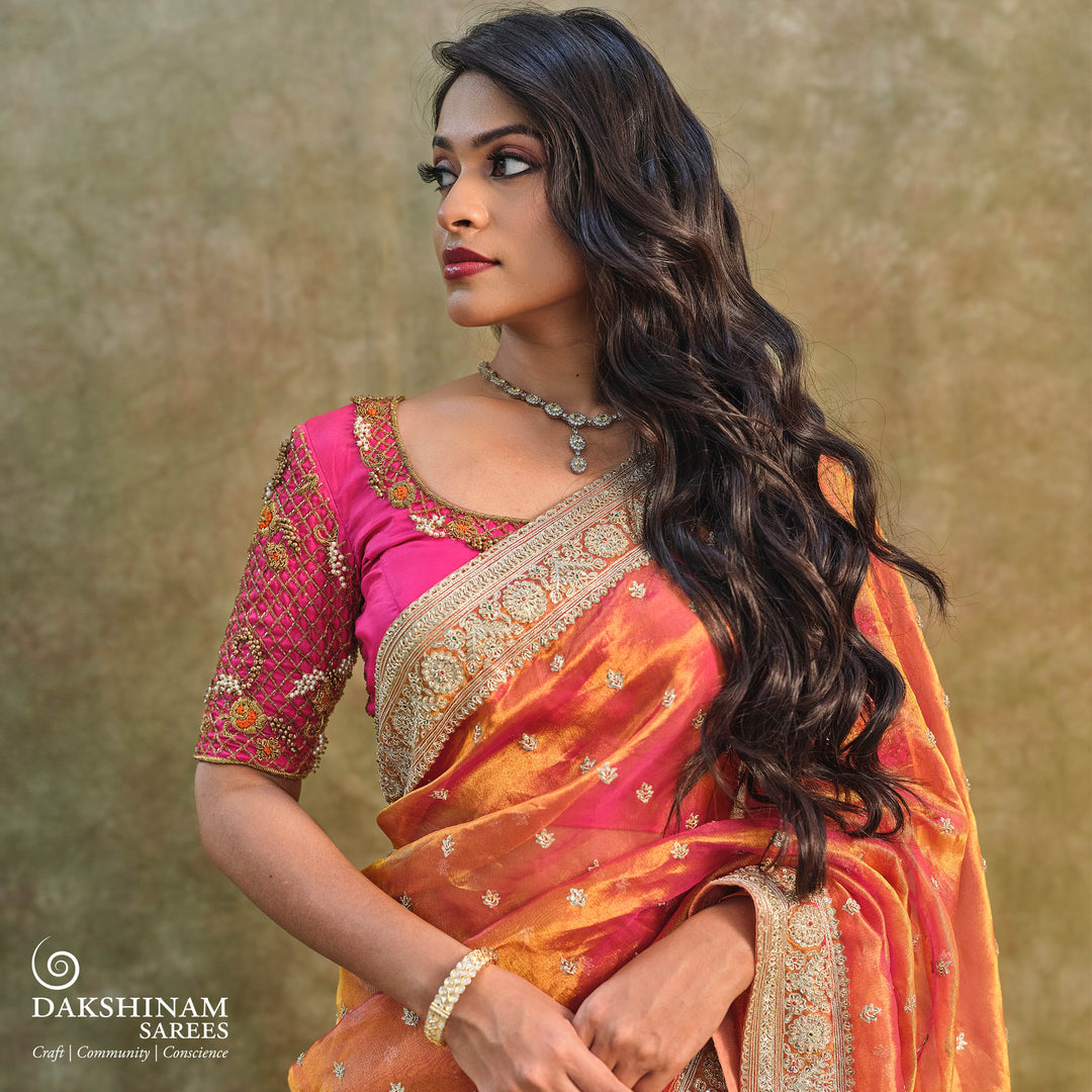 Orange embroidered tissue organza silk saree with small leaf zardozi buttas, ornate embroidered border and embroidered blouse.