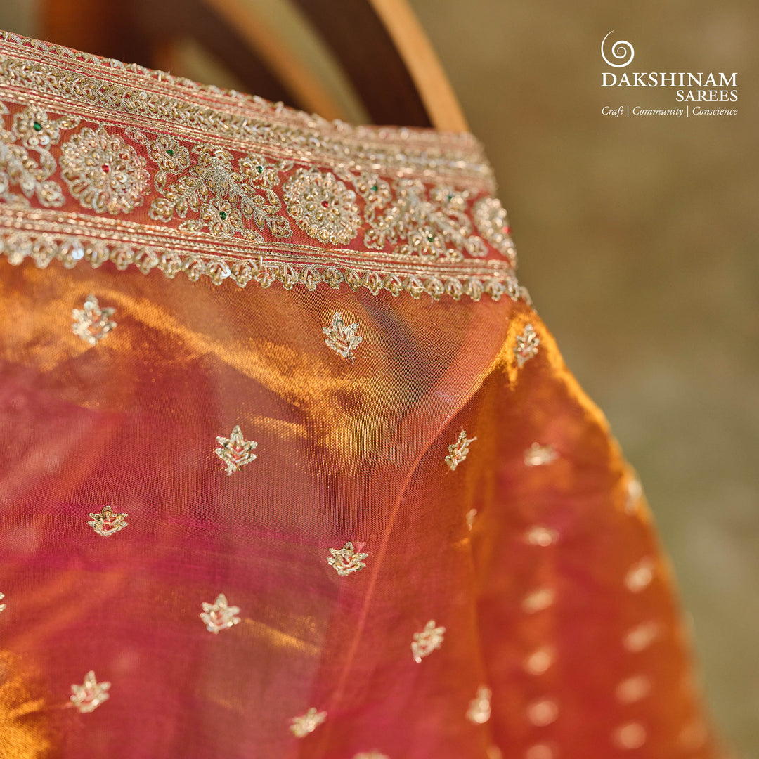 Orange embroidered tissue organza silk saree with small leaf zardozi buttas, ornate embroidered border and embroidered blouse.
