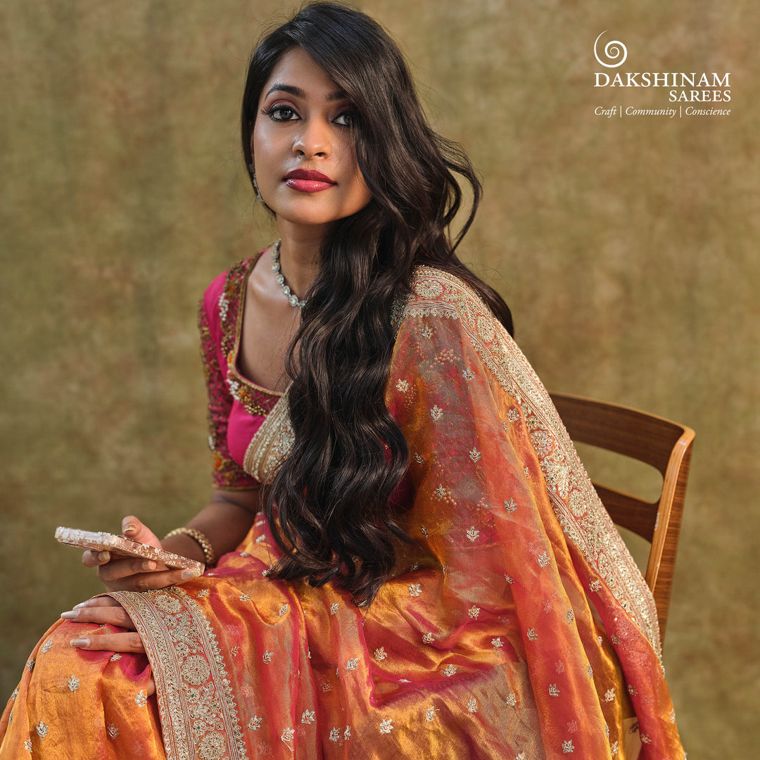 Orange embroidered tissue organza silk saree with small leaf zardozi buttas, ornate embroidered border and embroidered blouse.