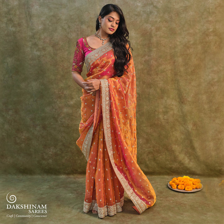 Orange embroidered tissue organza silk saree with small leaf zardozi buttas, ornate embroidered border and embroidered blouse.