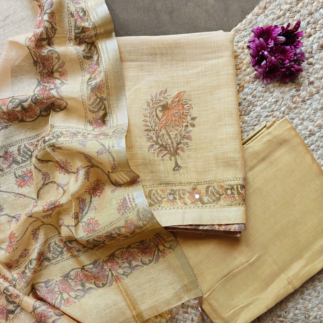 Elegant beige 3-piece suit set featuring floral prints with intricate applique work on a tissue base. Paired with a plain beige bottom and a floral printed Chanderi silk cotton dupatta for a graceful ethnic look.