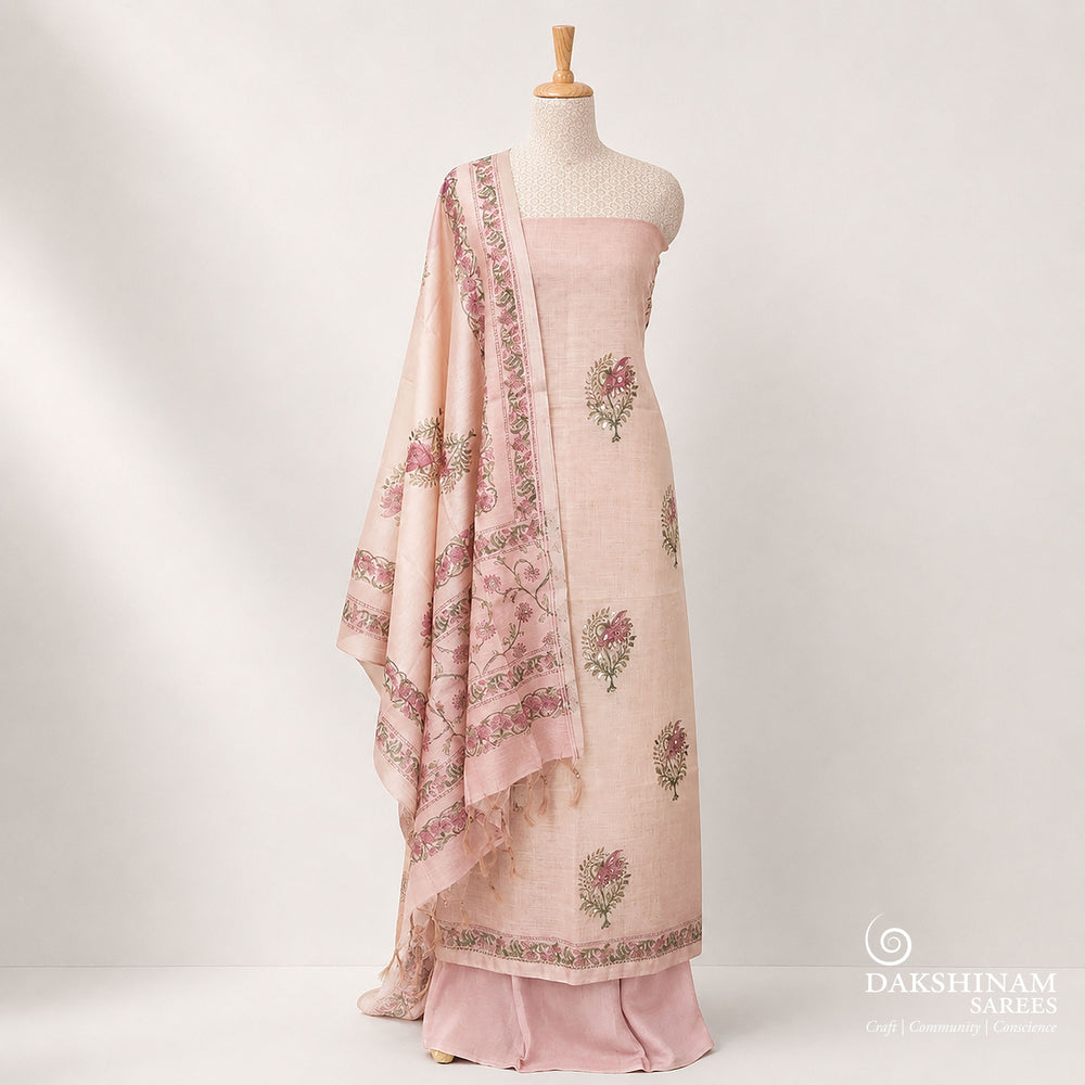 Elegant purple 3-piece suit set featuring floral prints with light orange applique work on tissue fabric. Paired with a plain purple bottom and a floral printed Chanderi silk cotton dupatta for a rich and graceful ethnic look.