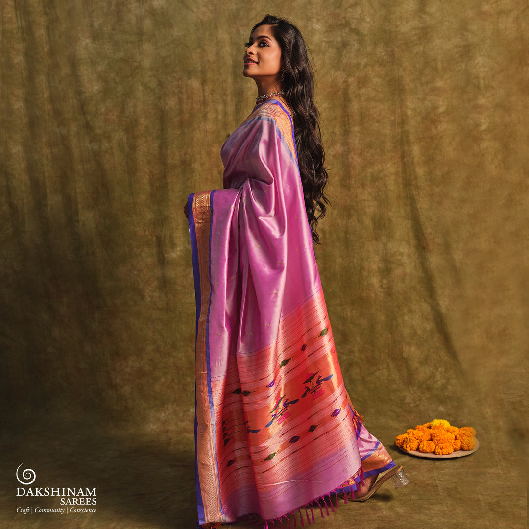 Lavender Paithani silk saree with gold zari paisley buttas, blue selvedge border with mayil motifs and traditional peacock pallu.