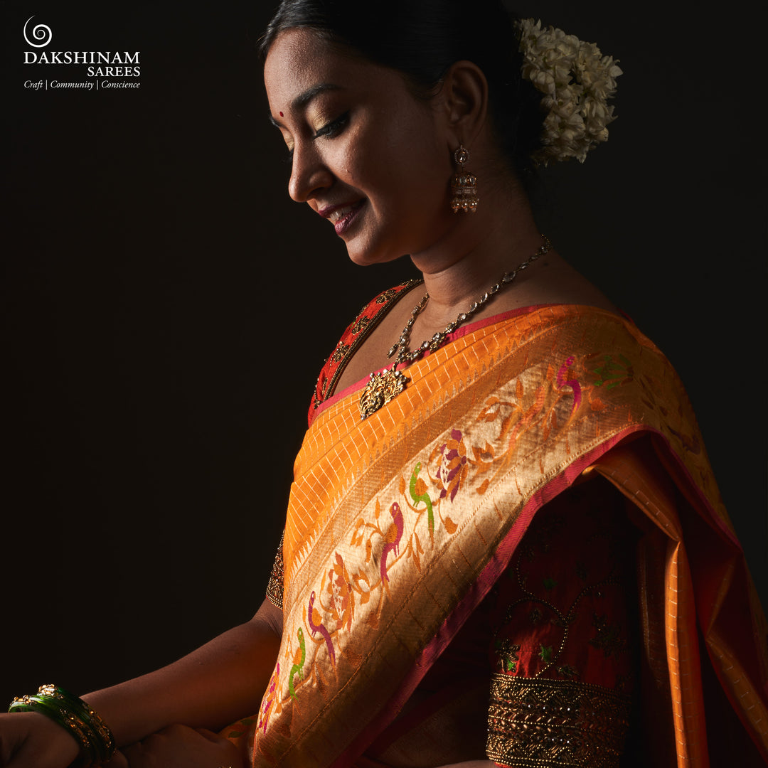 Orange Kanjivaram silk saree with checkered body, Paithani lotus vine and parrot border, pink selvedge and traditional pallu.