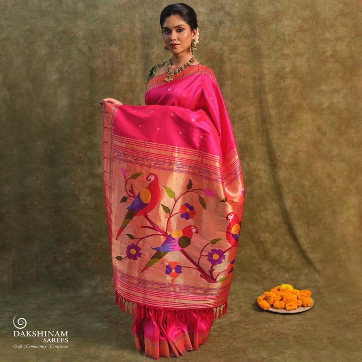 Pink Paithani silk saree with gold zari dotted body, tissue border with Munia motifs and multicolor parrot pallu.