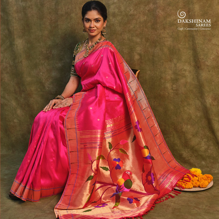 Pink Paithani silk saree with gold zari dotted body, tissue border with Munia motifs and multicolor parrot pallu.